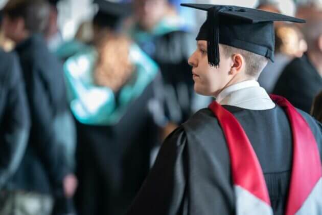 A graduate facing the stage at our Higher education graduation ceremonies.