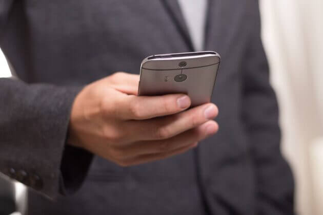 A male holding a mobile phone