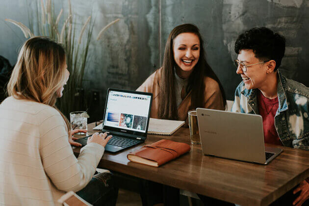 Students sat at a table with their laptops