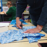 Someone cutting a piece of material ready to sew