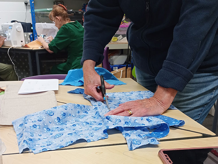 Someone cutting a piece of material ready to sew