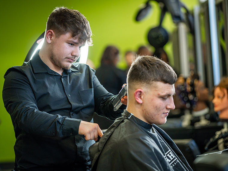 A student cutting a client's hair at the Rotherham College salon