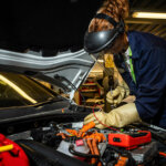 Motor Vehicle student looking under a car bonnet
