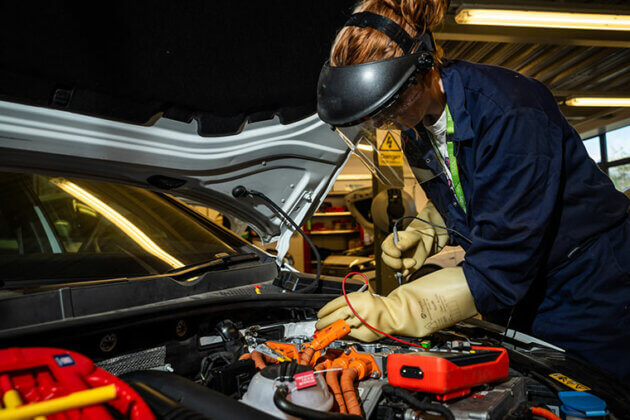 Motor Vehicle student looking under a car bonnet