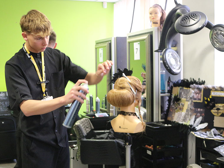 A student working on a hair style during the Intercollege 2025 competition