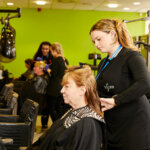 A student working on a client's hair in the salon