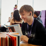 A student sat at a table reading a book