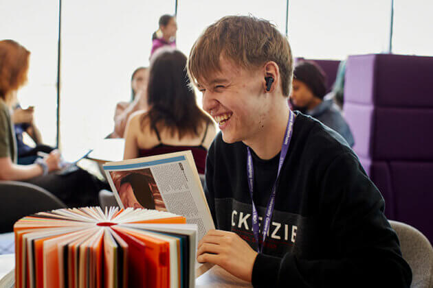 A student sat at a table reading a book