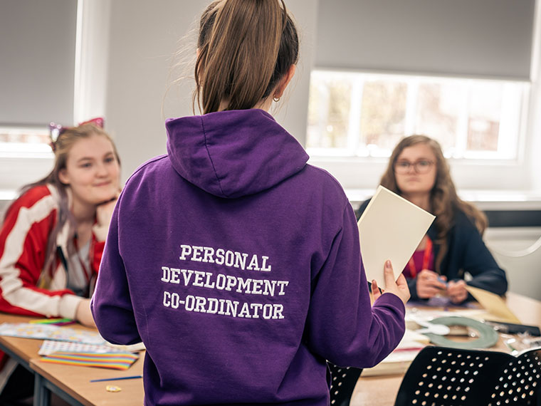 A Personal Development Coordinator talking to students