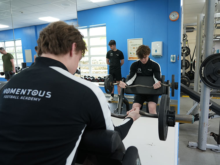 Momentous Football Academy training in the gym using weights
