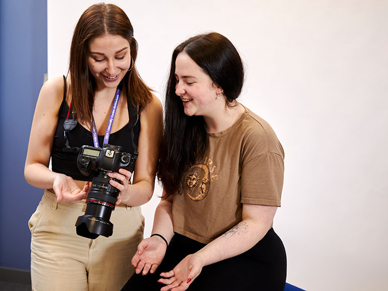 Two students looking at photos on a camera