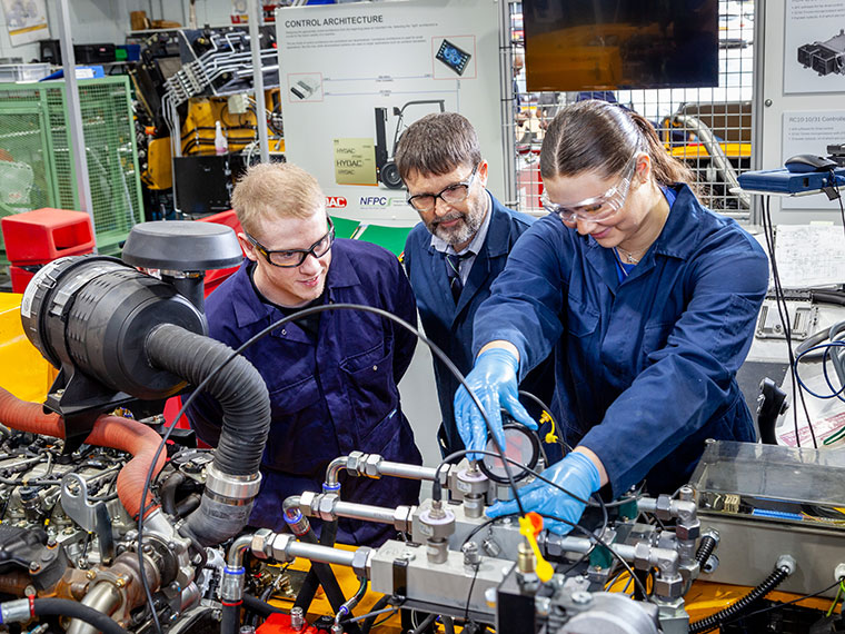 Two NFPC students being supported by a tutor