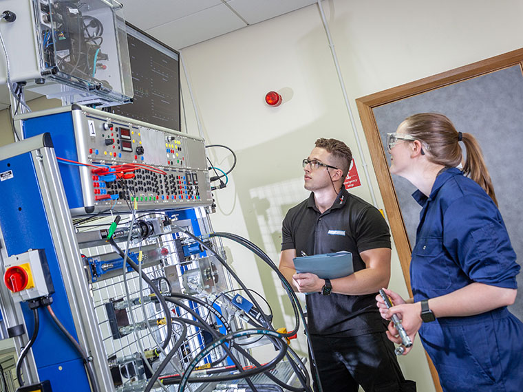 Two NFPC students looking at lots of cables