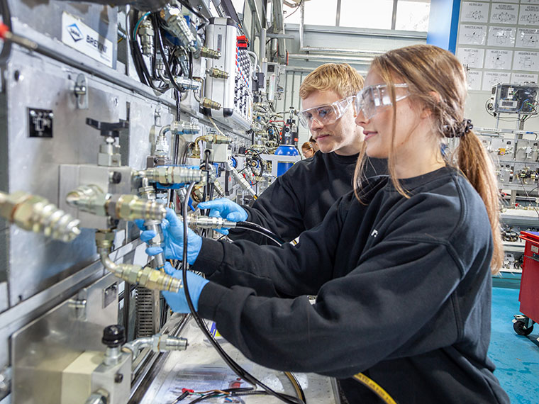 Two NFPC students looking at lots of cables