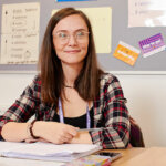 An adult learner sat at a table with open books in front of them