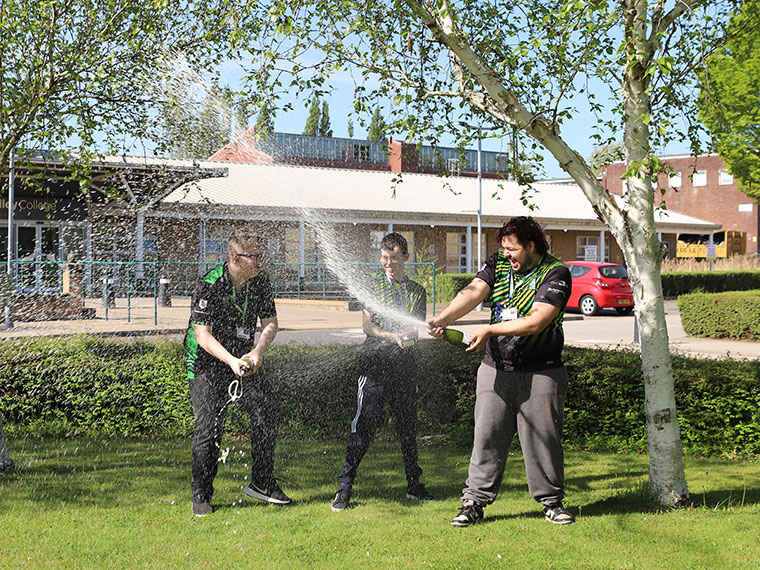 Three esports students celebrating winning a competition