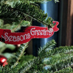 Seasons Greetings written on a decoration on a Christmas tree