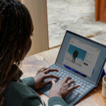 Someone sat at a desk working on a laptop at home