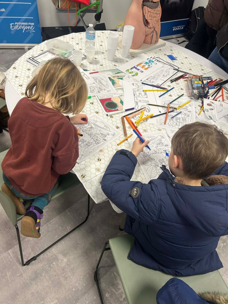 Children sat at a table drawing inside The Bridge Skills Hub in Worksop