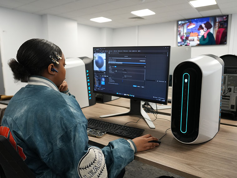 A student sat at a desk in front of a computer screen