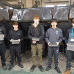 Five learners holding their welding work