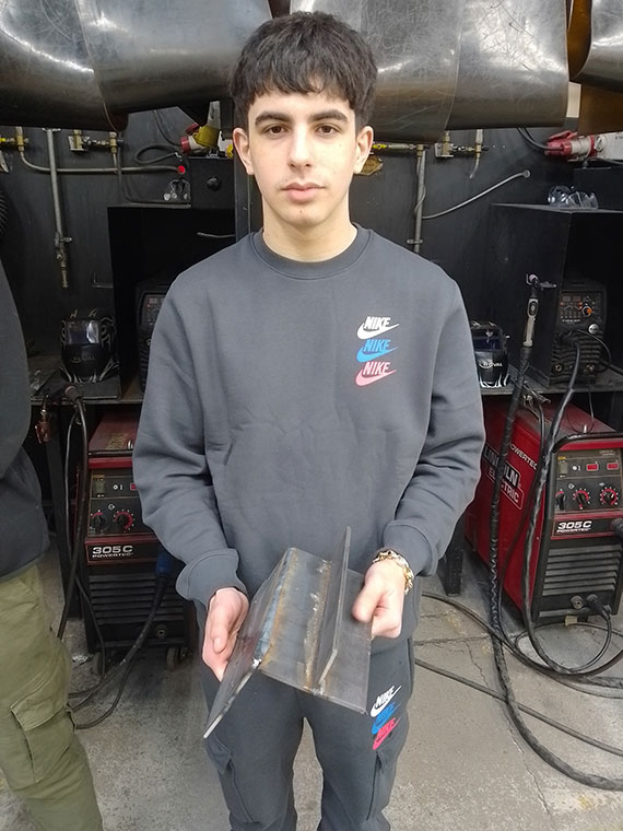 A Level 2 Welding learner holding his welding work