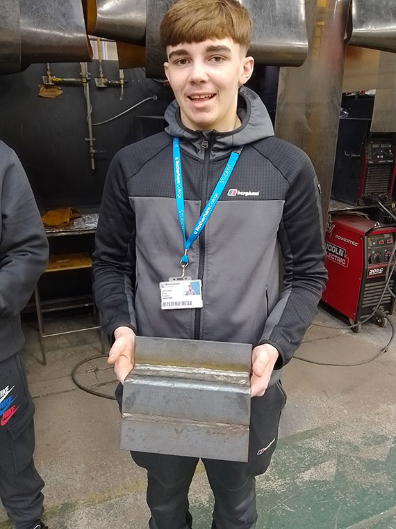 A Level 2 Welding learner holding his welding work