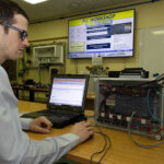 Someone sat in front of a monitor and other machinery