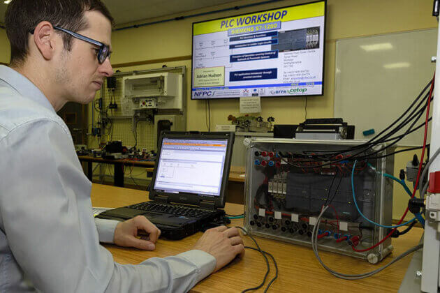 Someone sat in front of a monitor and other machinery