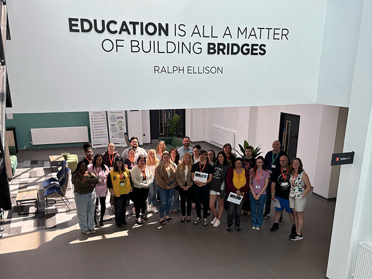 A group of adults stood together inside The Bridge Skills Hub