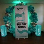 A circle of balloons and a pull up banner at the RNN Group's Employer Awards