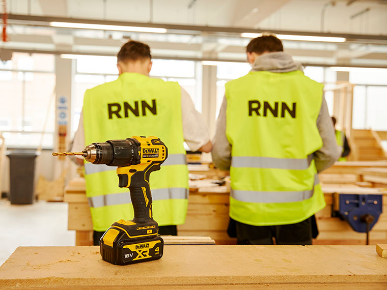 Two people wearing high vis jackets with their backs to the camera