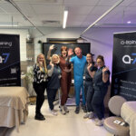Six people stood together with two beauty therapy beds next to them and three a-training pull up banners