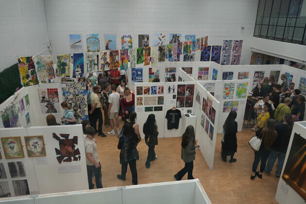 Rotherham College's creative showcase 2025 - People looking at student's artwork hung on the wall