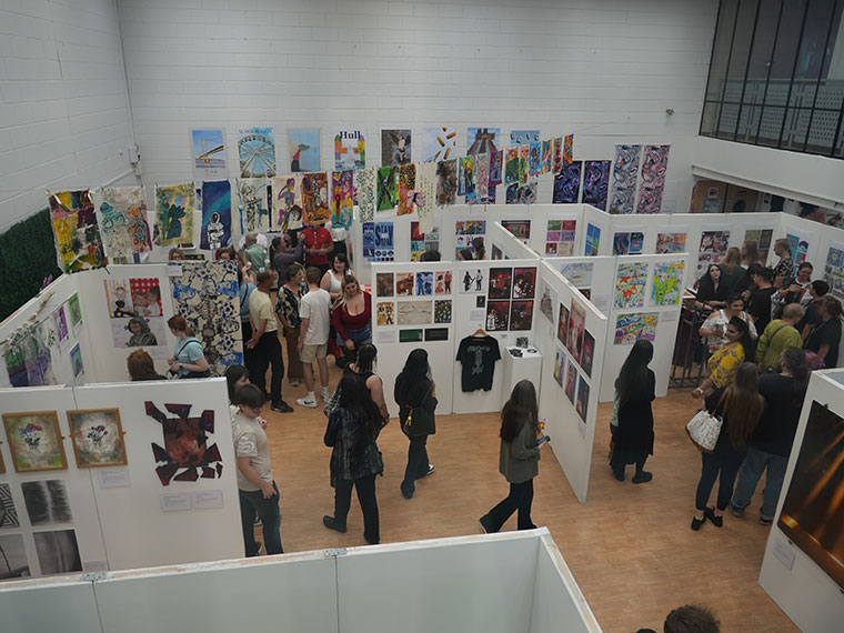 Rotherham College's creative showcase 2025 - People looking at student's artwork hung on the wall