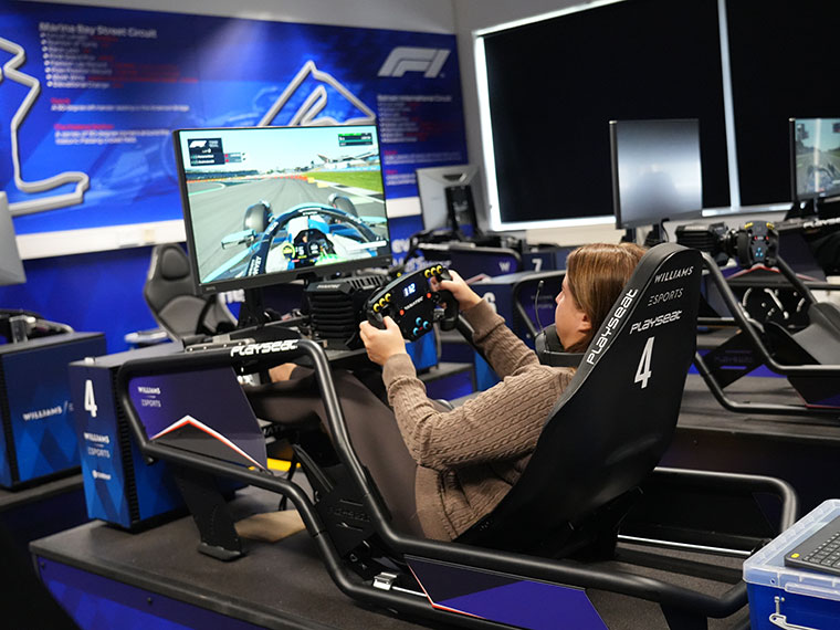 Someone sat on an Esports F1 Simulator looking at the screen in front of them