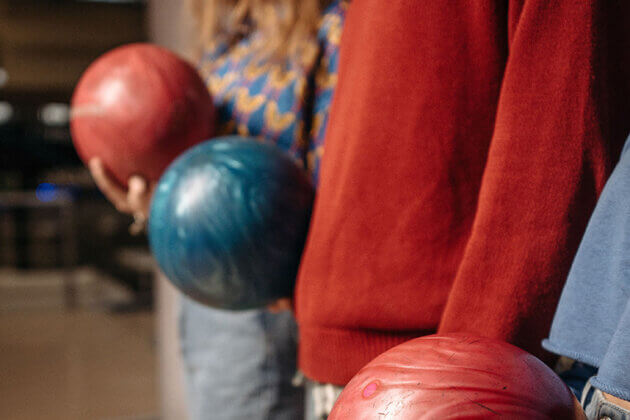 A close up of people holding bowling balls