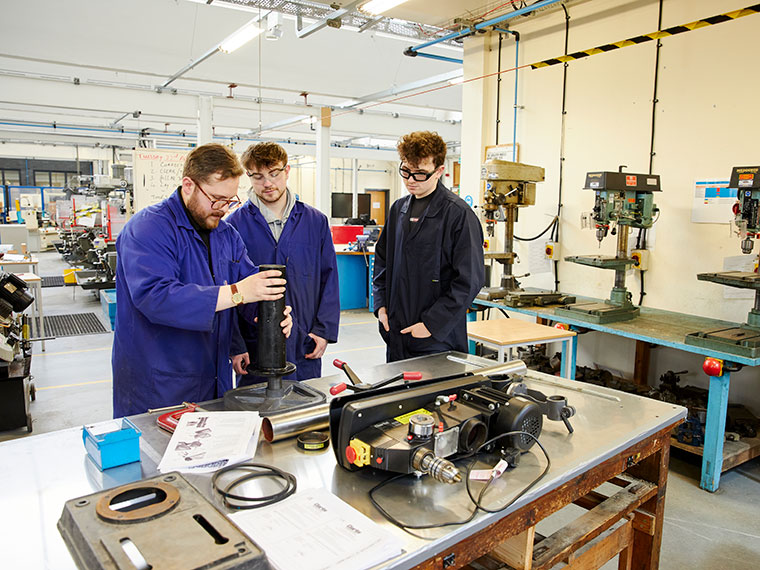 Two students listening to their engineering tutor