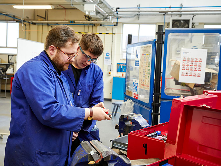 An engineering student using machinery in the workshop