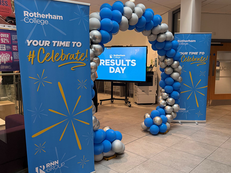 Two Rotherham College pull up banners with the text 'Your time to celebrate' stood each side of a balloon arch