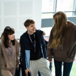 Three students talking whilst walking up the stairs