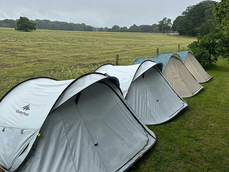 A line of four tents in a field