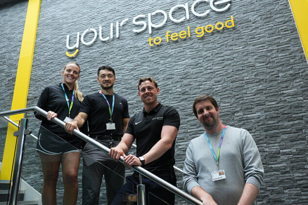 Your Space to feel good written on a wall with four people stood below it on a staircase
