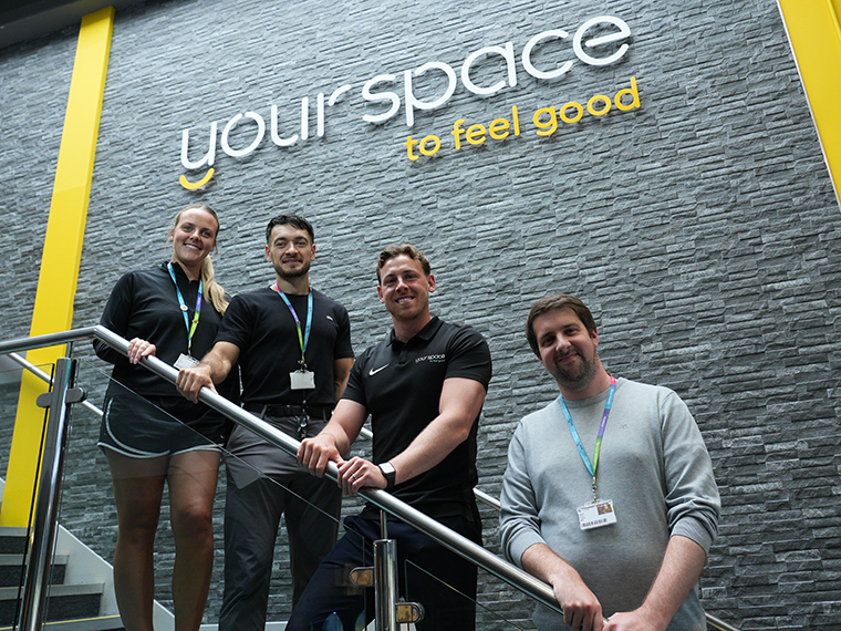 Your Space to feel good written on a wall with four people stood below it on a staircase