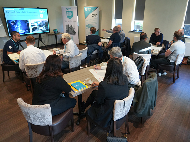 A group of people sat on tables in The Wharncliffe, a large screen at the front of the room